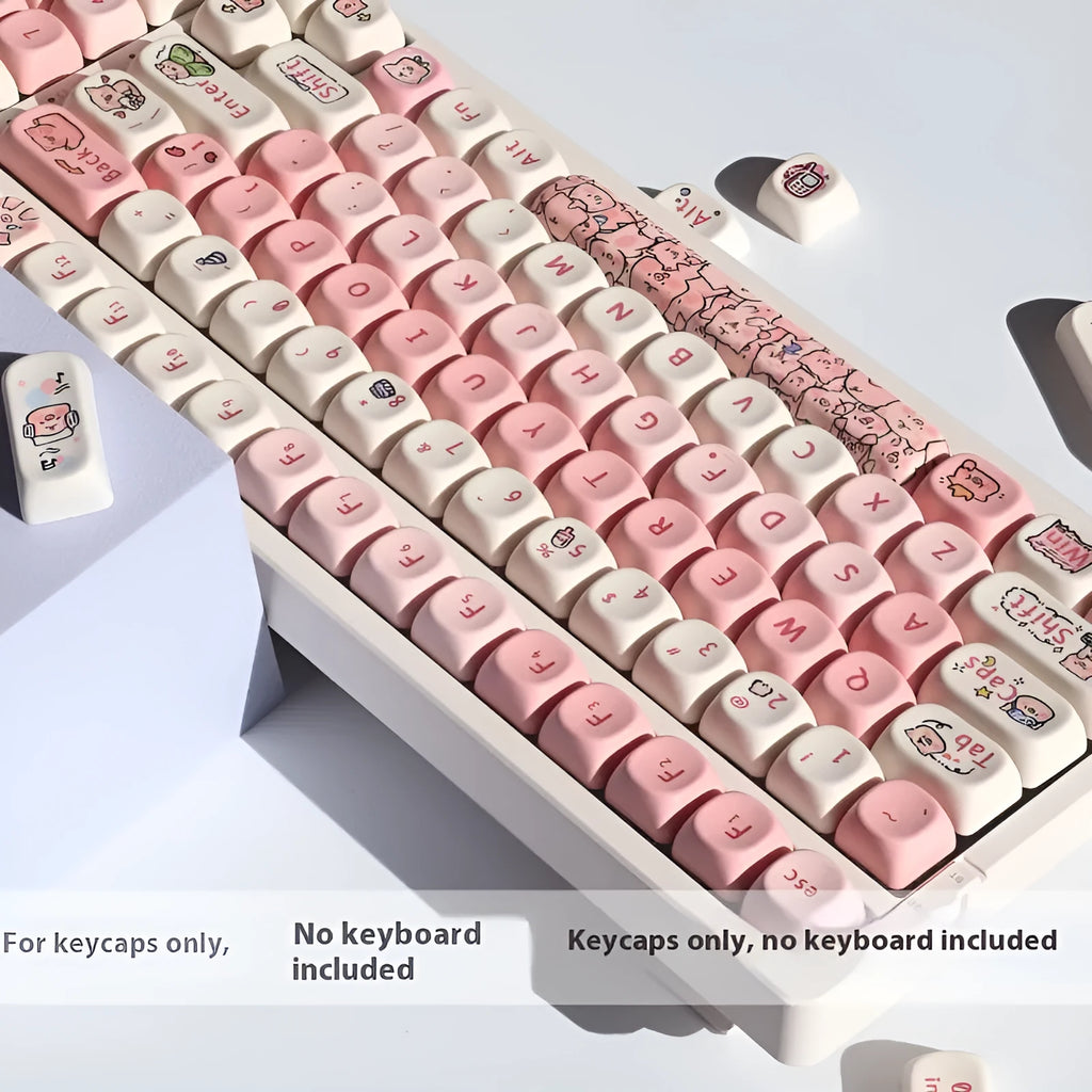 Set of pastel pink PBT key caps with a fragrant pig design, shown with a key puller tool.