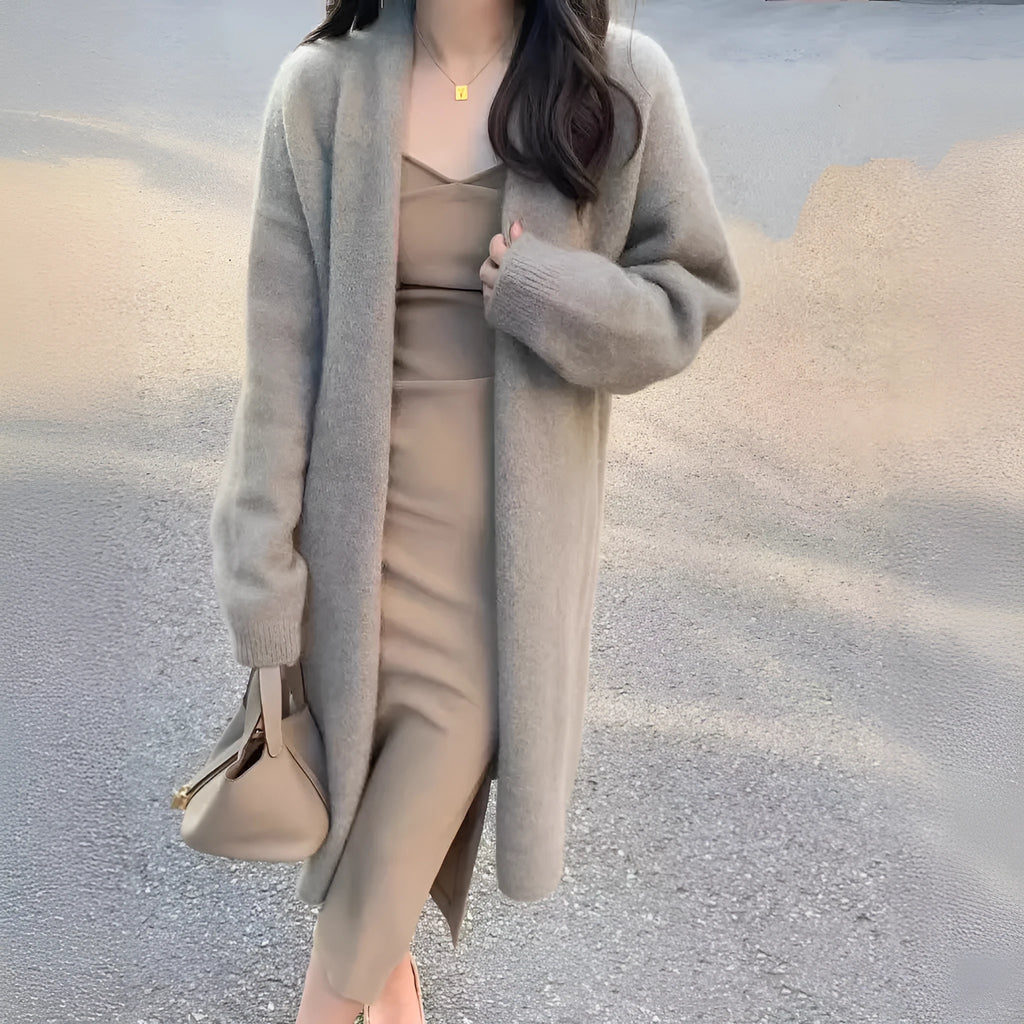 A women's khaki knitted V-neck cardigan with long sleeves, shown hanging to display its mid-length loose fit.