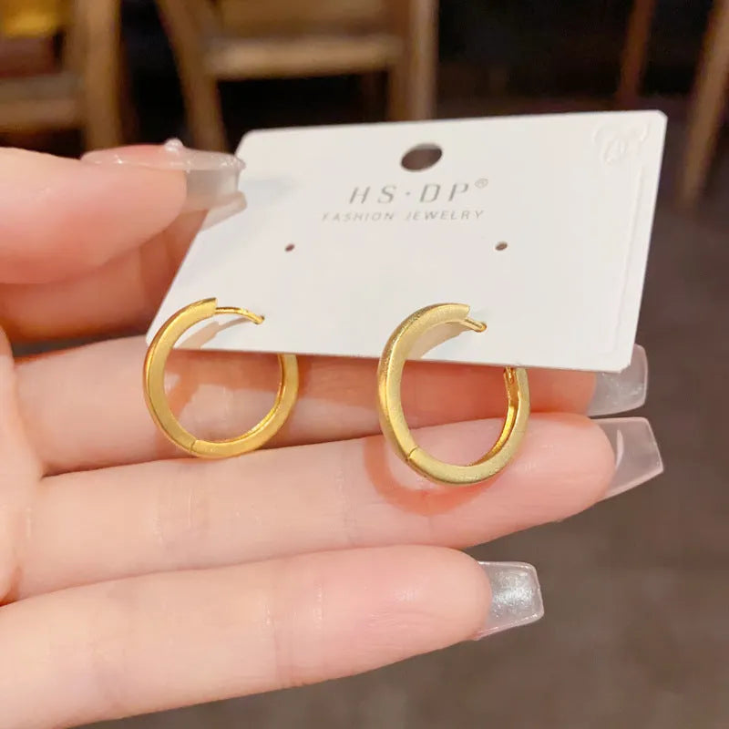 Geometric women's ear clip with round eyelet in gold or silver plating.