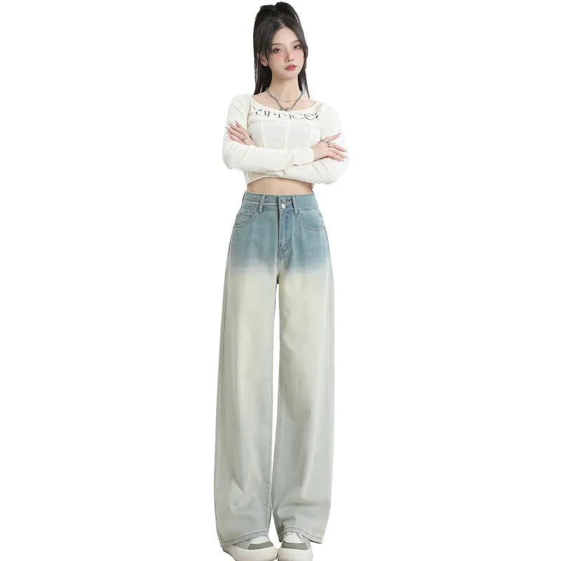 Women's gradient blue straight-leg denim trousers on a hanger, showing wide-leg silhouette.