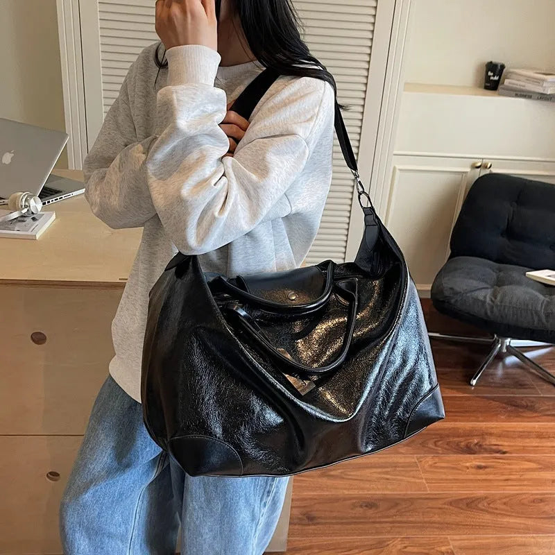 Large hand-carry travel bag for women in black colour showing storage capacity