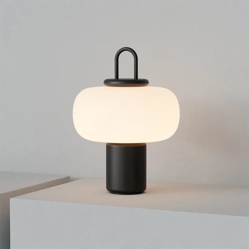 Minimalist Japanese glass bedside table lamp with warm light for a child's bedroom.