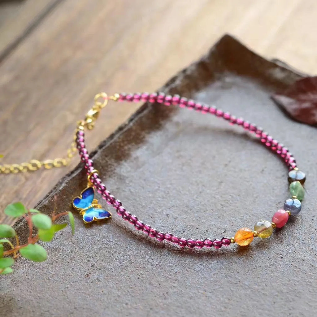 Close-up of a purple garnet anklet with a geometric design on a female ankle.