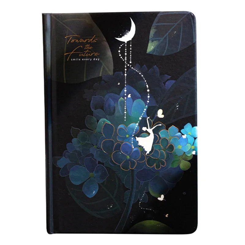 A5 notebook with a luminous cover shown in deep blue, open to reveal pages with colour illustrations.