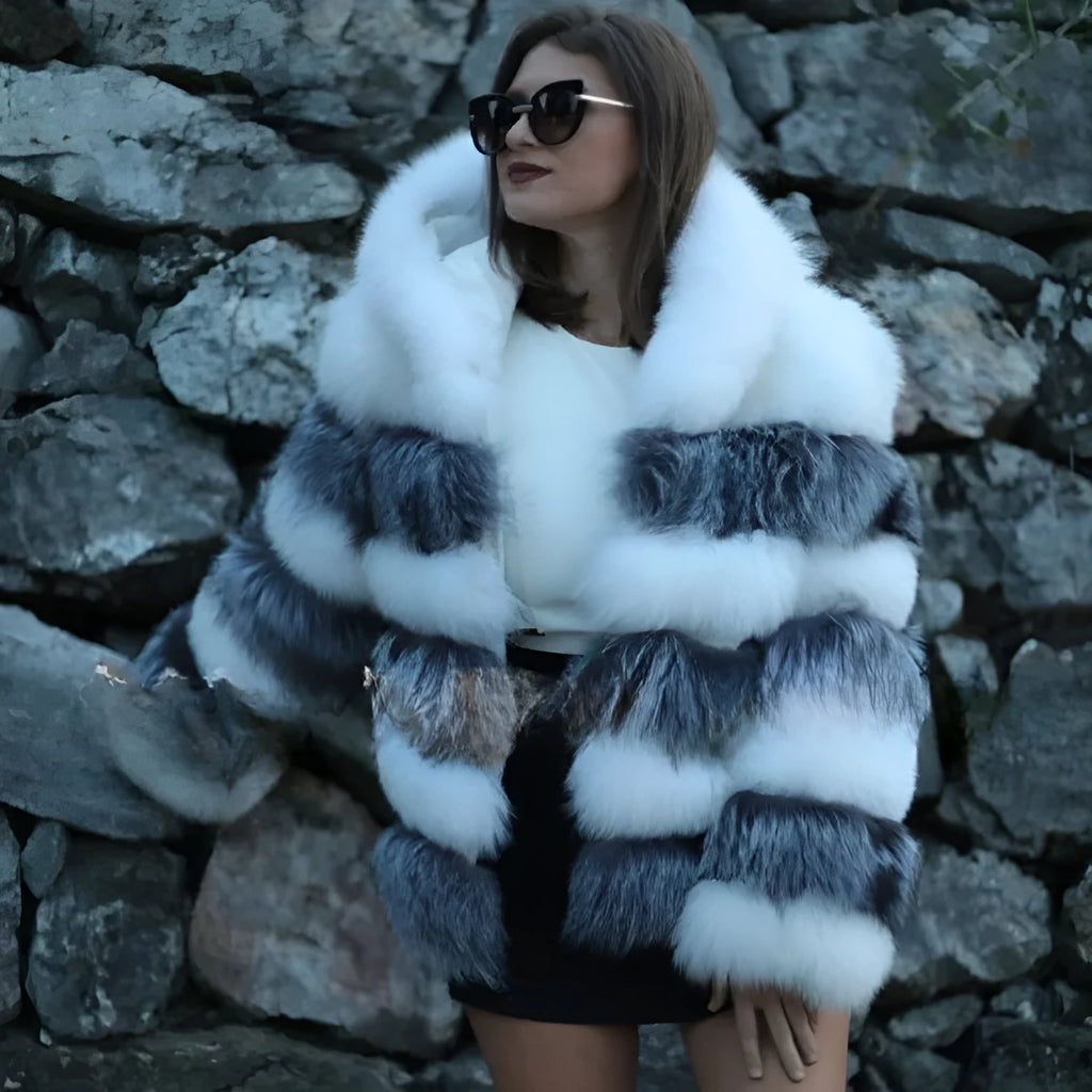 A woman wearing a loose-fitting artificial fur coat with a hood, in a street fashion style.
