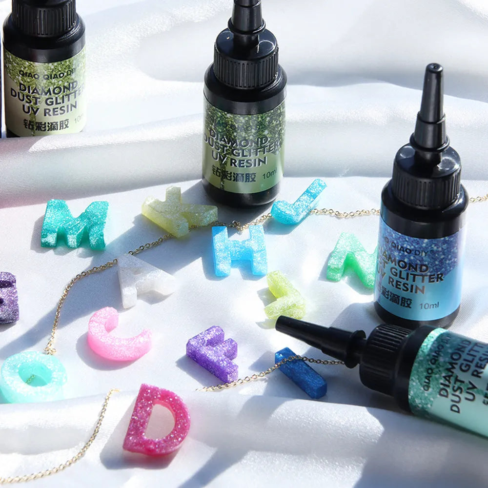 UV epoxy diamond 24 colour set with gold, silver, blue, pink, and green sequins on a white surface
