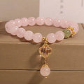 Pink crystal women's bracelet with four-leaf clover pendant charm and rhinestone decoration.