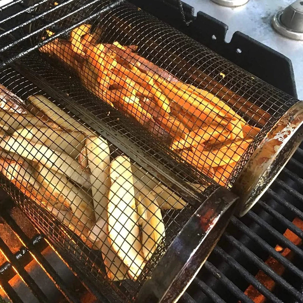 Stainless steel cylindrical rolling barbecue grilling basket with wire mesh on a grill.