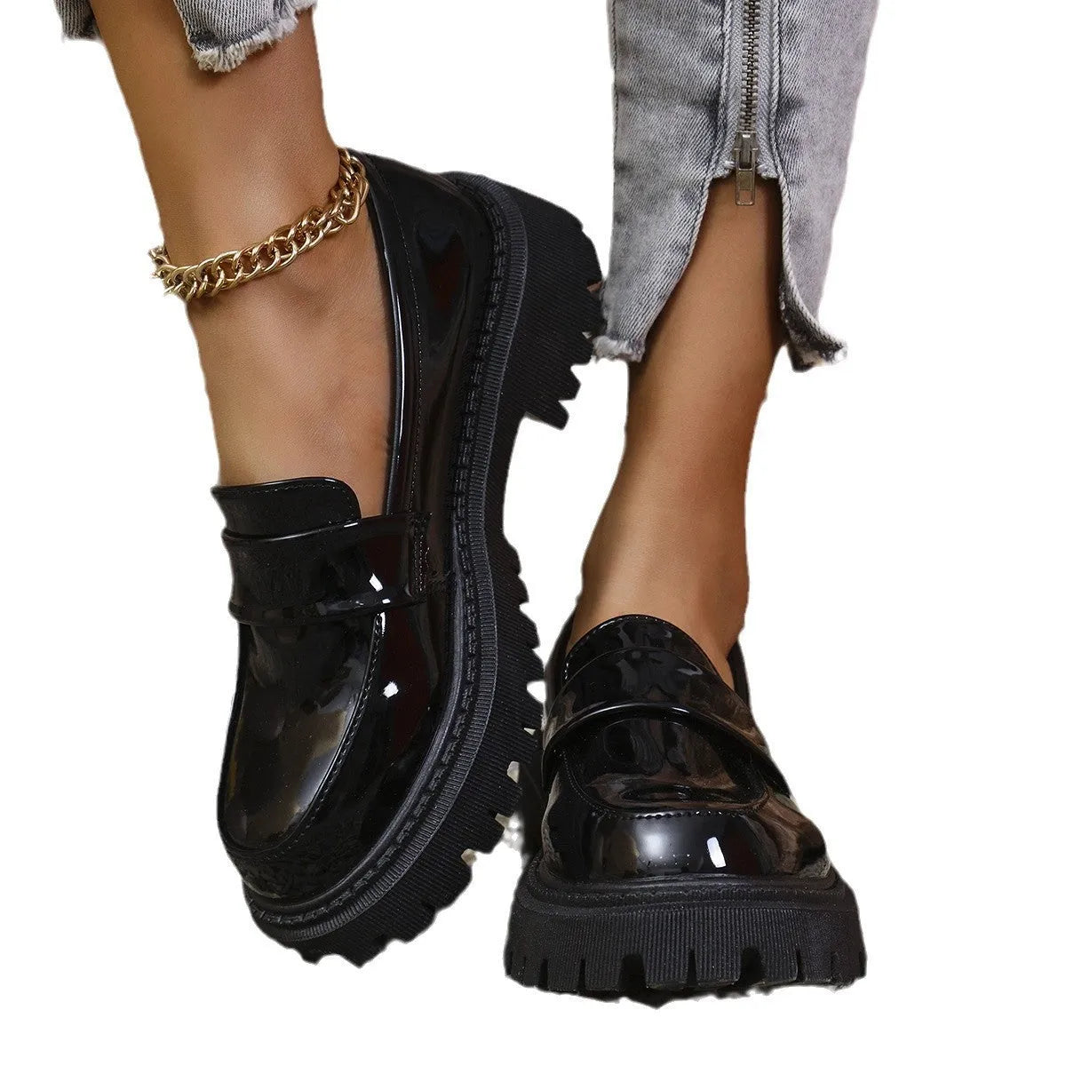 Black British style slip-on loafers with a chunky platform heel and thick rubber sole on a plain background.
