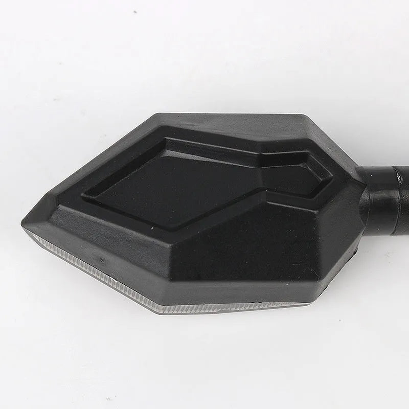 Arrow-shaped LED motorcycle turn signal light with 12V label and ABS plastic housing.