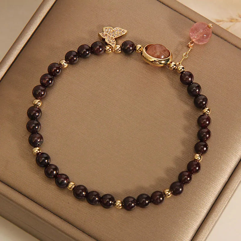 Black butterfly pendant bracelet with stone construction and red rock elements