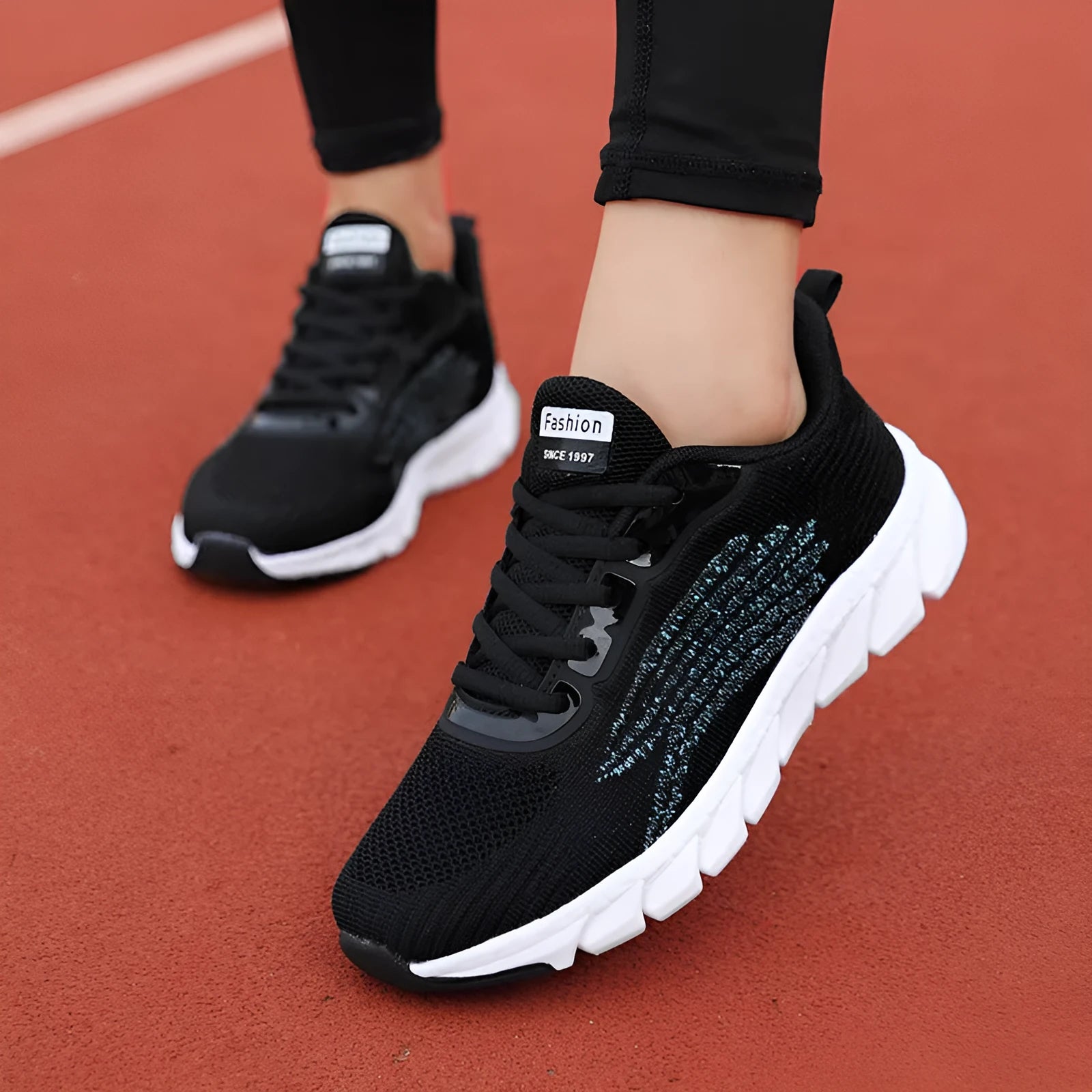 Women's black and white low-top running sneakers with cross strap design and MD soles
