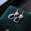 A pair of lapis lazuli pearl drop earrings on 925 silver posts with engraved patterns.