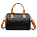 Cylindrical crossbody bag in brown PU leather with three shoulder straps showing textured exterior