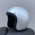 Retro-style open-face motorcycle helmet in cement grey with a textured finish and quick-release chin strap.
