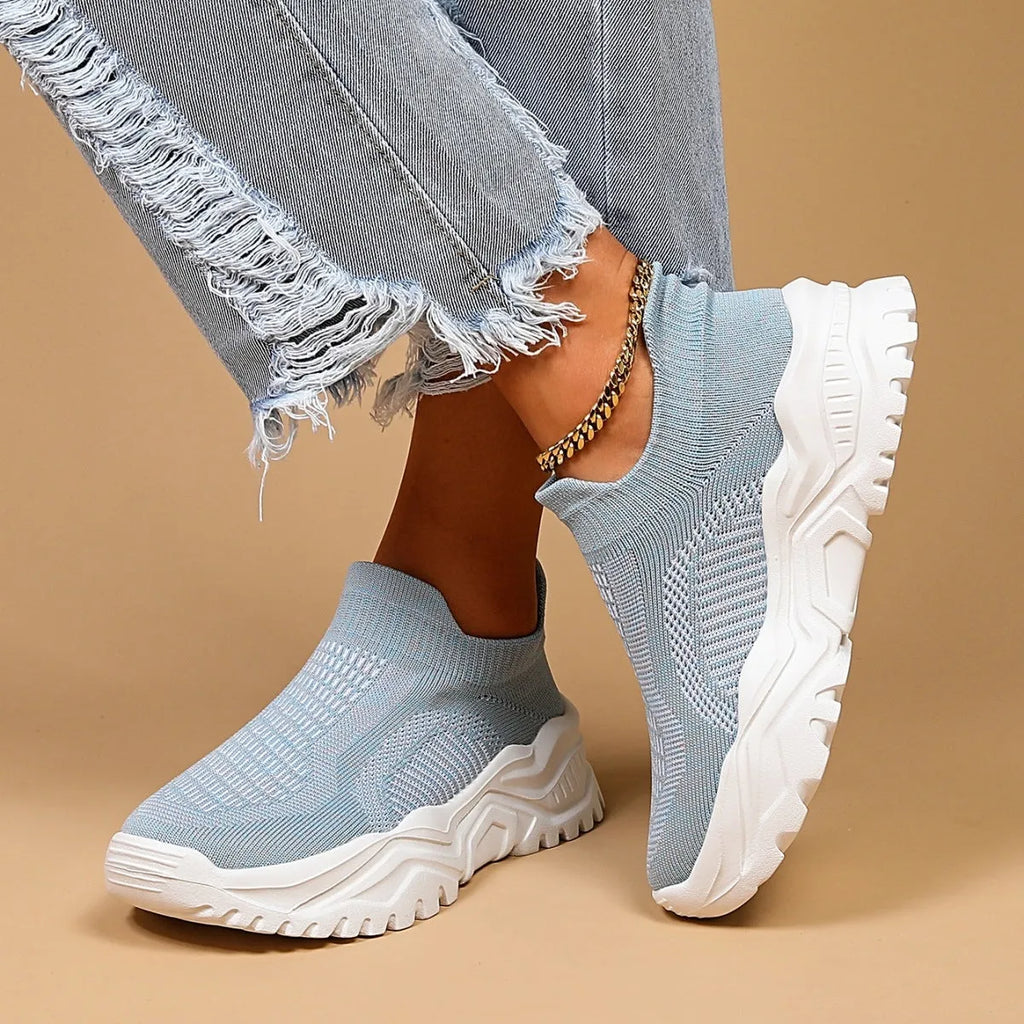 Women's light blue mesh slip-on sports shoes with a rounded toe and mid heel.