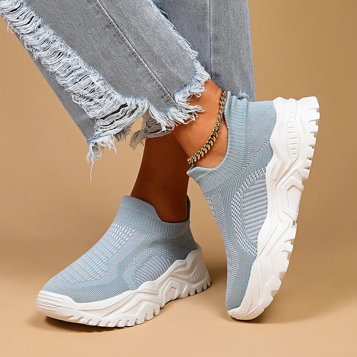Women's light blue mesh slip-on sports shoes with a rounded toe and mid heel.