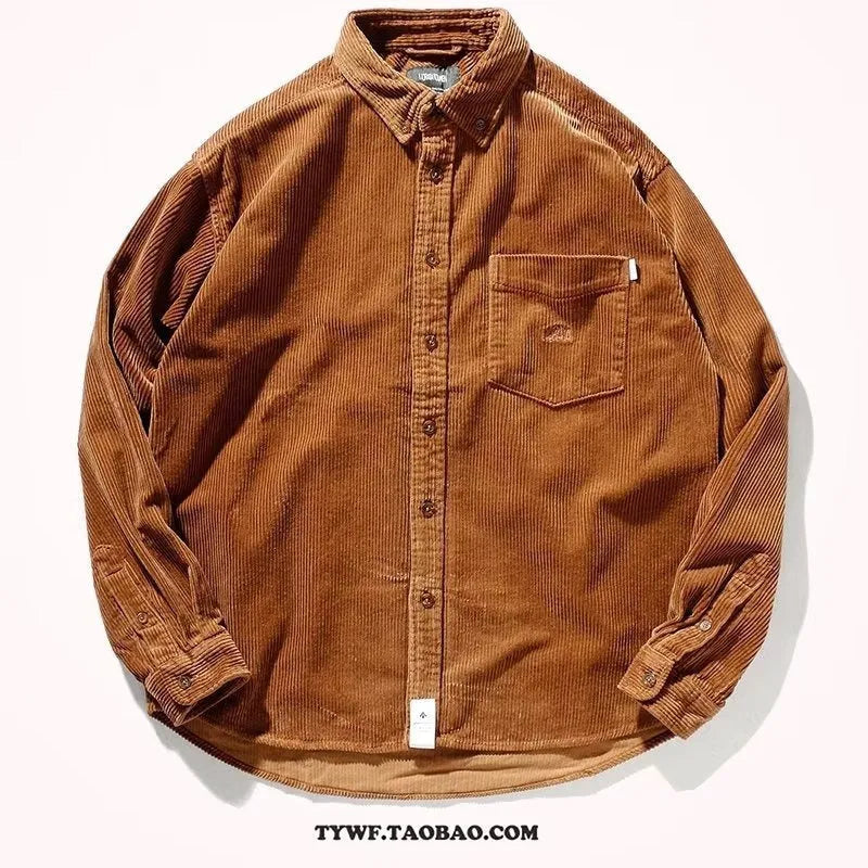 Caramel coloured loose fit corduroy cardigan shirt with long sleeves on a hanger.