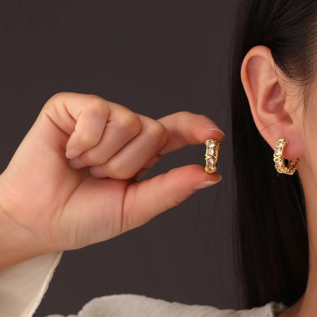 A pair of geometric hexagonal clover cross design earrings with an electroplated gold or silver finish.