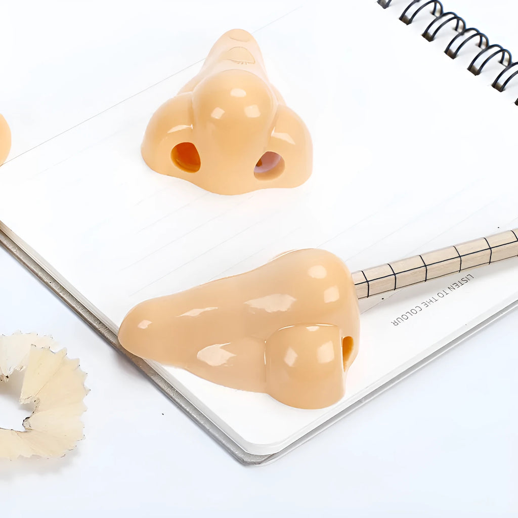 Flesh-coloured plastic manual pencil sharpener with a geometry shape, shown next to a pencil for scale.