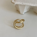 Geometric open ring with interlaced matte metal design in gold or silver plating.