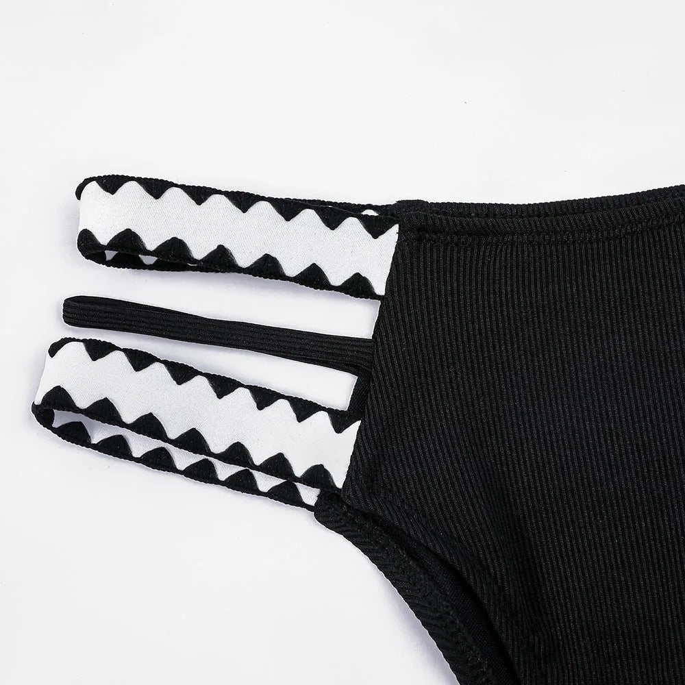 Black women's hollowed-out split swimsuit bikini on a neutral background