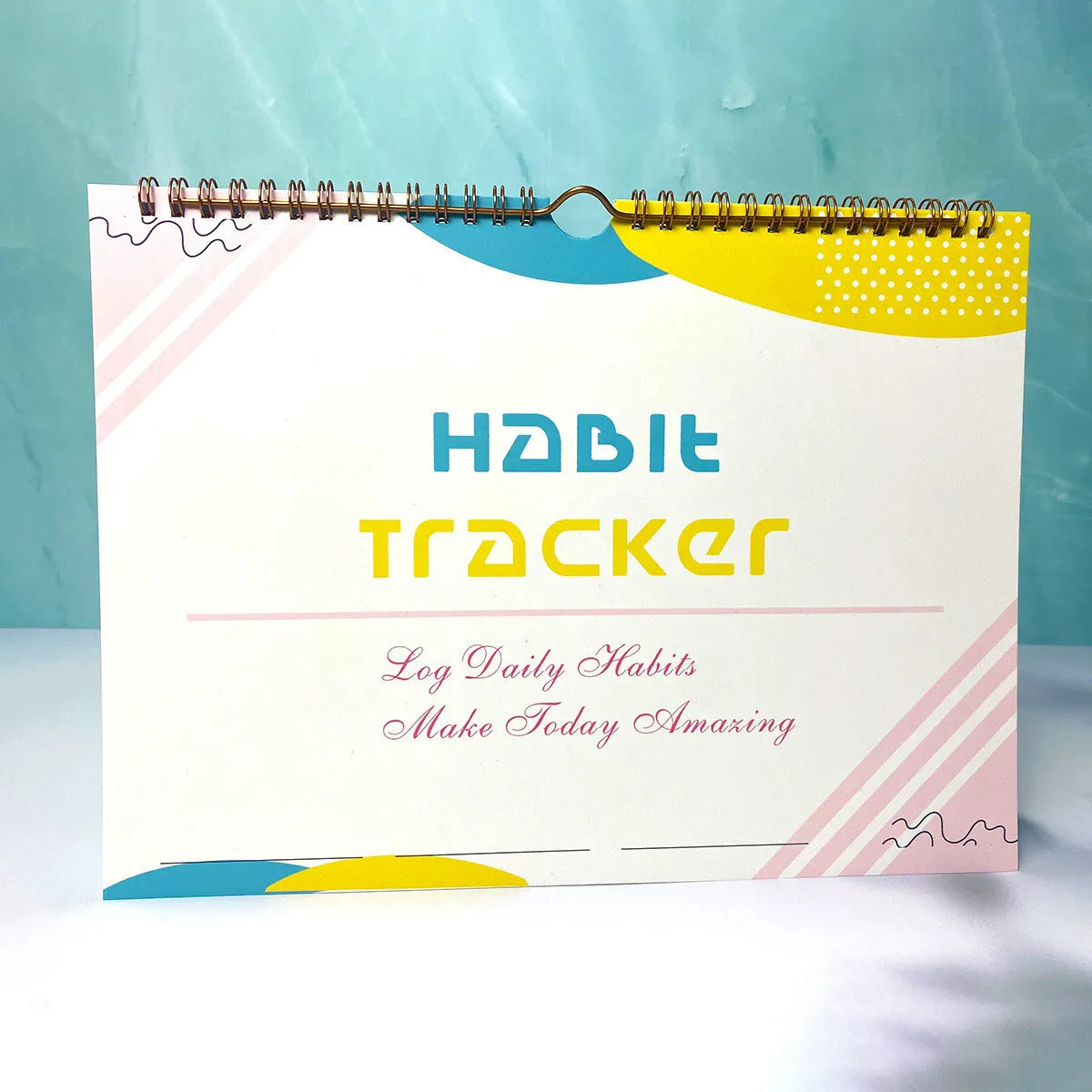 A5 habit tracking notebook open on a desk, showing internal pages, available in four colour options.