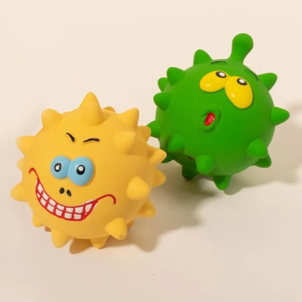 Set of four colourful squeaky dog balls with cute faces on a natural latex rubber texture.
