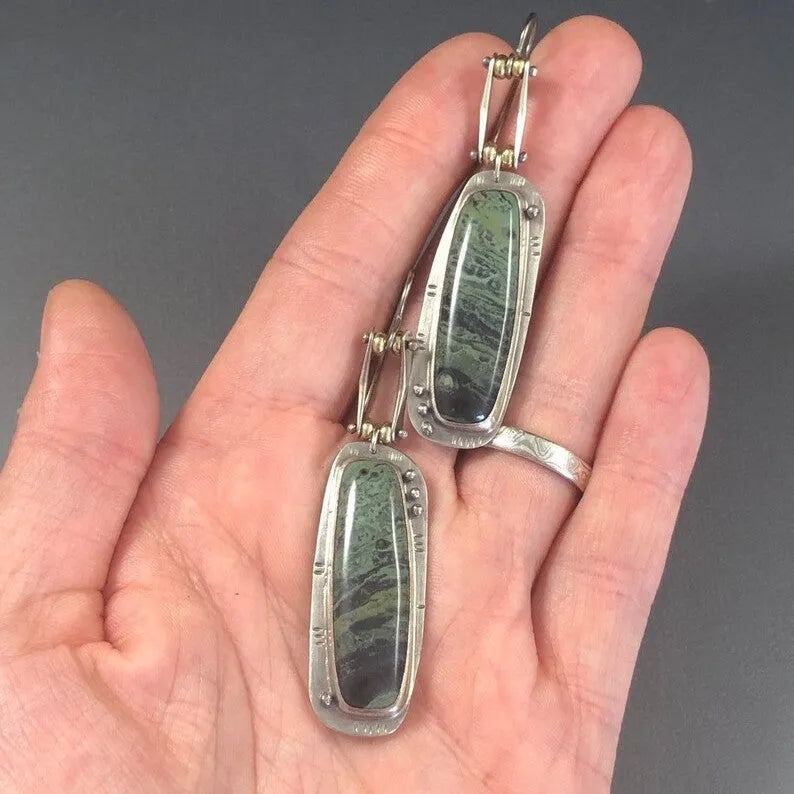 A pair of geometric drop earrings with a white and grey marble pattern on an alloy background.