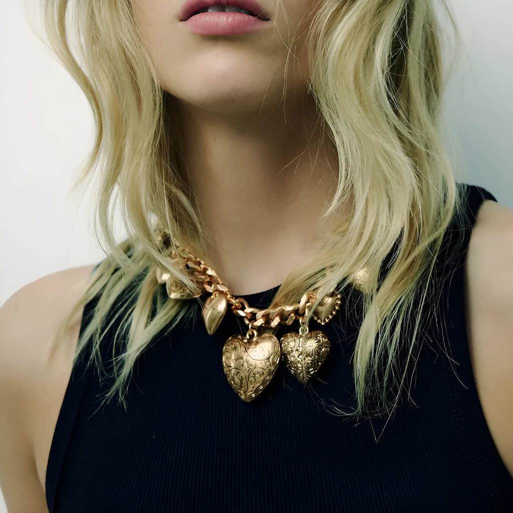 Gold tone carved heart-shaped pendant on an adjustable metal chain necklace.