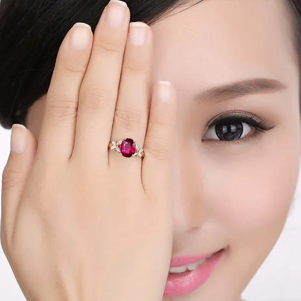 Close-up of a women's rose gold plated butterfly ring shaped like a heart with coloured enamel details.