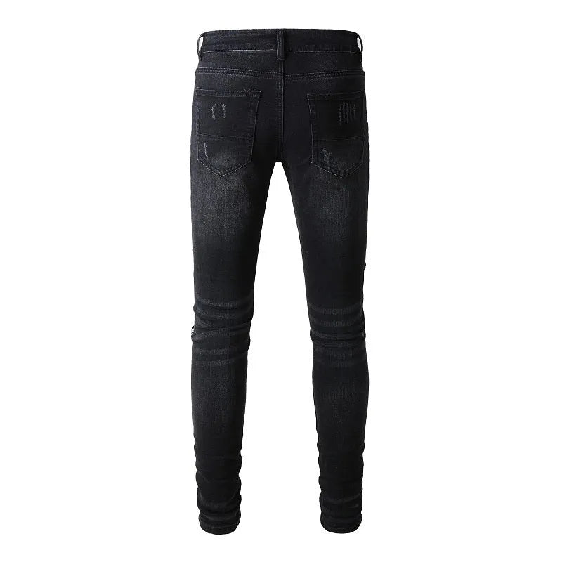 Men's black tattered stretch denim jeans with printed patch on a white background, front view