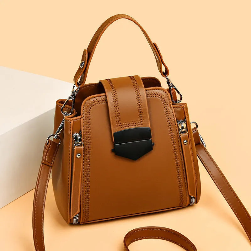Small square vertical ladies handbag in soft textured PU leather, showing sewing thread detail.