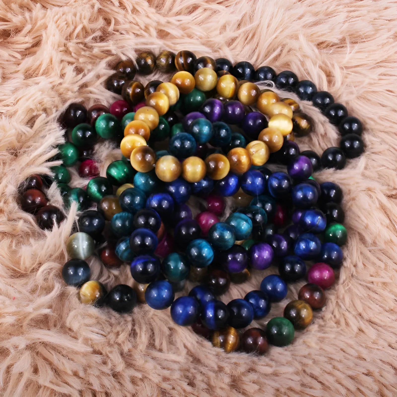 Natural tiger's eye crystal bracelet with round geometric beads in various colours and sizes on a wrist.