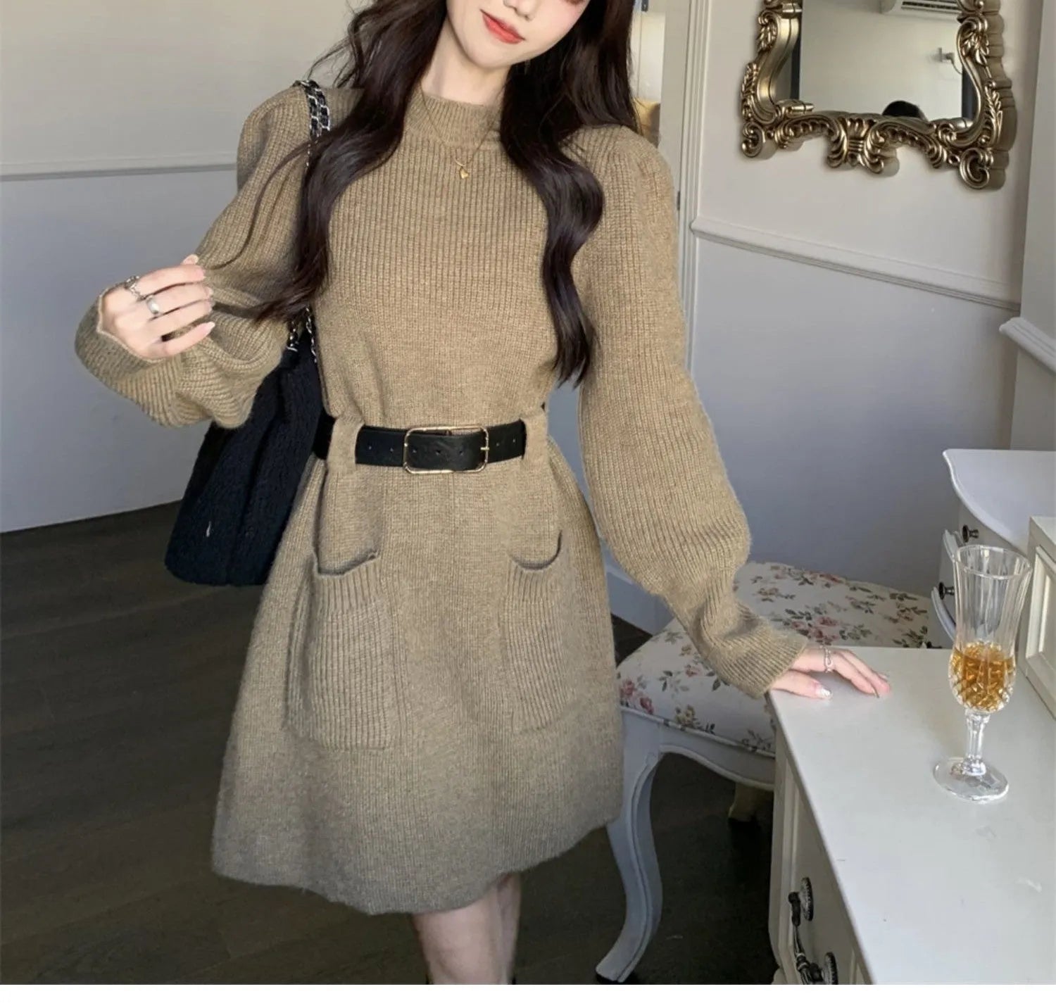 Women's beige loose knitted long sleeve dress with high waist and a black belt.