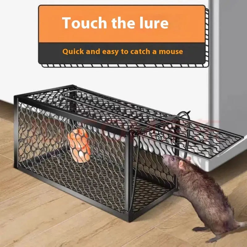 Automatic mouse cage trap with clear plastic dome and one-touch release lever at the base on a wooden floor.