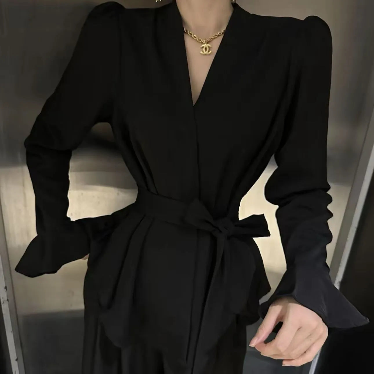 Women's black French-style shirt with an irregular collar and long bell sleeves, tied at the front.