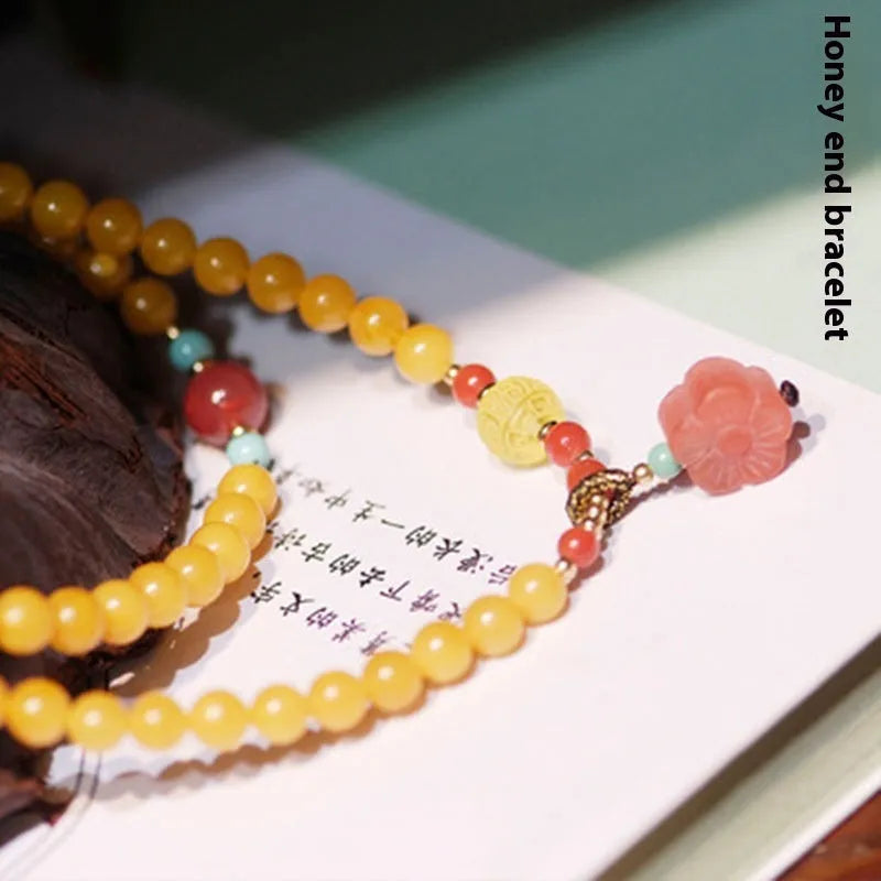 Yellow amber chicken grease beeswax bracelet with 5mm beads and Zodiac modelling on a wrist.