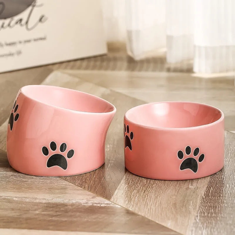 Ceramic cat food bowl with high foot base in a cat's paw print design