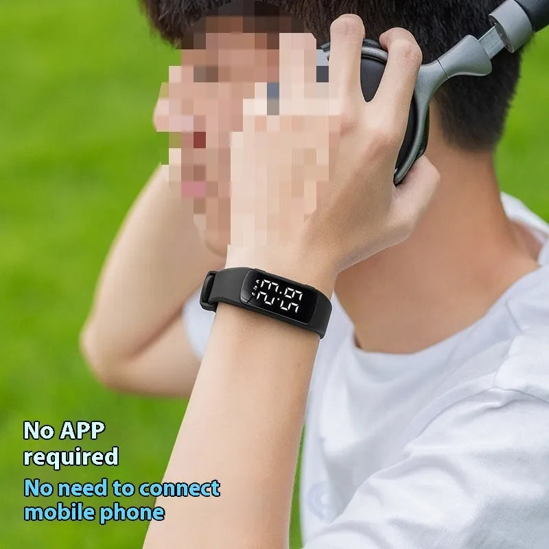 Black electronic digital watch with LED display and silicone strap on a wrist.