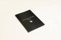 Black hardcover dream journal notebook with ruled pages open on a table.