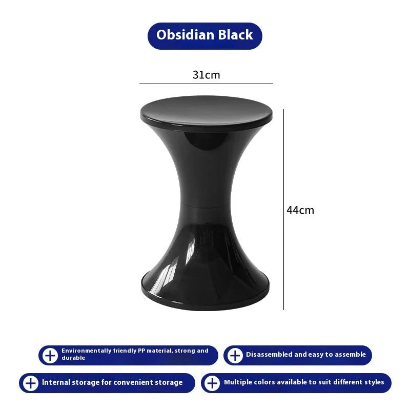 Green plastic hourglass-style shoe changing stool on a wooden floor.
