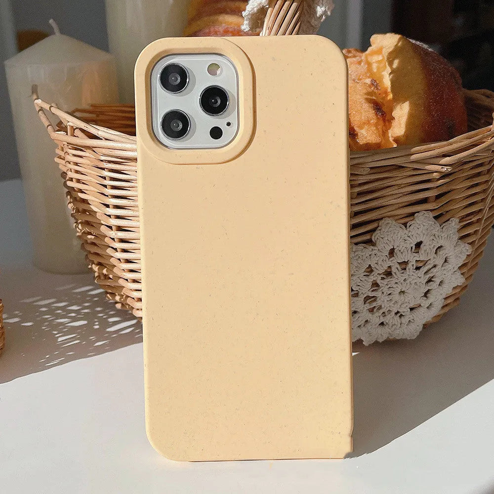 Biodegradable wheat straw mobile phone case for iPhone in seven colour options on a table.