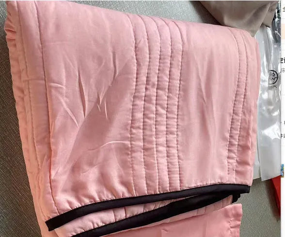 Lightweight seersucker summer quilt in various colours on a bed