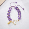 Close-up of a women's woven bracelet with 6mm aquamarine beads and a butterfly charm on a wrist.
