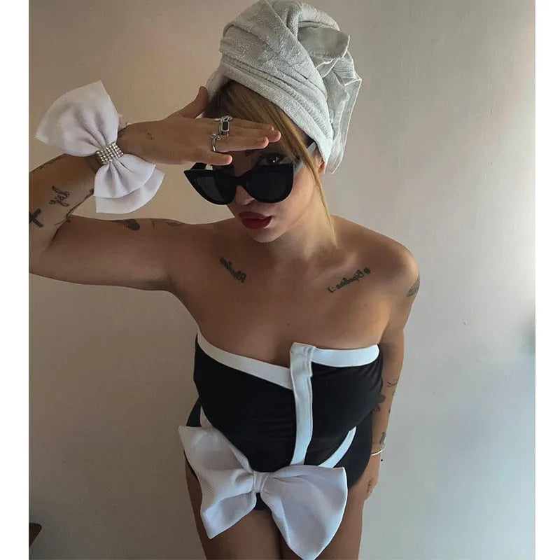 Women's black and white colour-block one-piece swimsuit with asymmetrical bow detail and tube top design