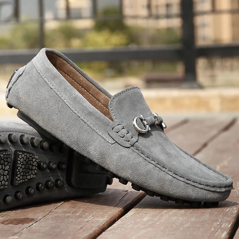 Men's black slip-on leather shoes with square toe and flat rubber sole on a neutral background.