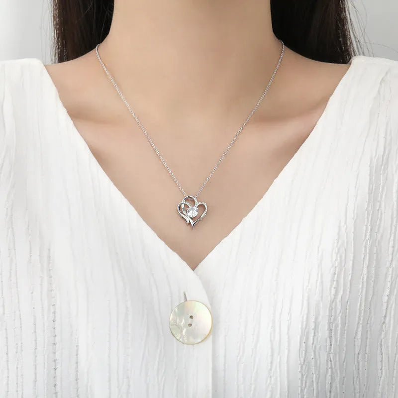 Women's heart-shaped 925 silver necklace with diamond-cut treatment on a model.
