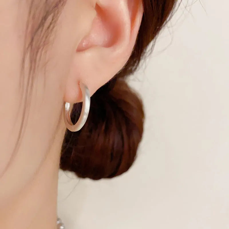 Geometric women's ear clip with round eyelet in gold or silver plating.