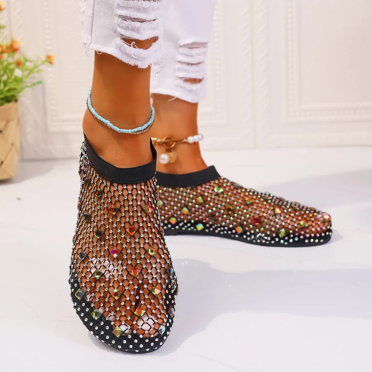 Women's flat sandals with a colourful rhinestone design on a breathable mesh upper and a rubber sole.